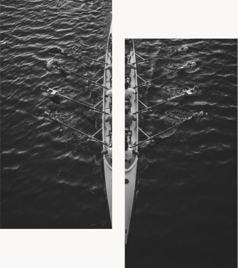 Ruderboot auf ruhigem Wasser, mit Schwimmern in der Nähe.